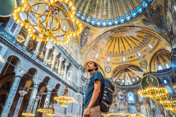 Man tourist enjoying Hagia Sofia, Ayasofya interior in Istanbul, Turkey, Byzantine architecture,...