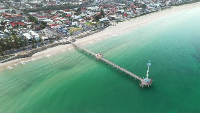 Aerial wide view of Brighton jetty, beach and surrounding township, ending in a top down view over Brighton jetty and back. Adelaide, Austalia.