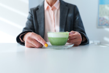 Woman drinks matcha green tea from a transparent cup