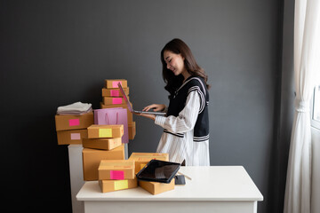 business owner young woman asian with long hair Check the notebook product order. On the table are...