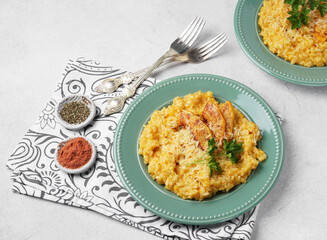 Risotto with pumpkin on the green plate on the table. top horisontal view, copy space