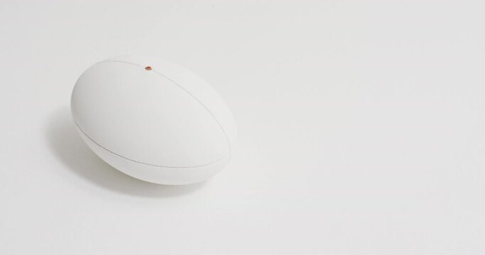 White rugby ball on white background with copy space, slow motion