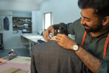 menswear designer working on a bespoke jacket in his studio 