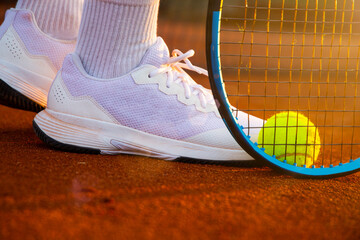 Symbolbild Tennis: Nahaufnahme von einem Tennisspieler auf einem Sandplatz