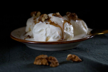 Creamy ice cream balls with nuts in a plate on the table