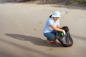 Asian young woman Cleaning and collecting trash on the beach