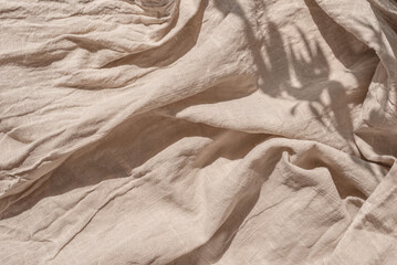 Abstract neutral background, crumpled draped linen fabric texture on sun light with soft shadows,...