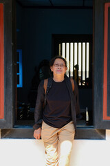 Asian woman standing in front of black old wooden window frame in a China town