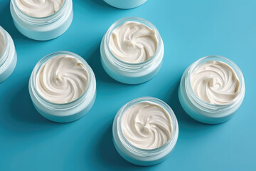 Above view of open white round plastic jars of cream with swirl of cosmetic cream isolated on a flat blue background. Generative AI 3d render illustration imitation.
