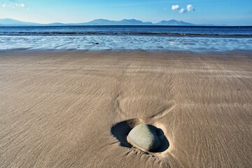 Fototapeta na wymiar Stone on Newborough beach, Anglesey, Wales, United Kingdom, Europe. A lonely stone on a sandy beach. 