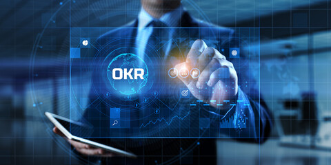 OKR Objectives key results. Businessman pressing button on screen.