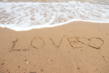 Writing the English alphabet, the word "Love" and "heart" on the sandy bottom, then the sea water erases the letters. Ideas for recording your love in letters or drawings.