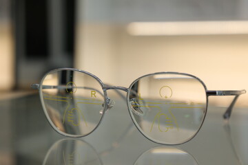 Fototapeta na wymiar Eyeglasses on table, progressive lenses, eyeglasses for the elderly, glasses progressive lens, eyeglass progressive lens, close-up of glasses on lenses test, looking through glasses