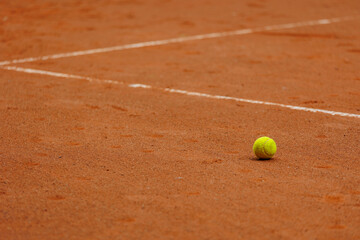 tennis court covered with red clay for championship or sports competition. tournament for athletes. healthy lifestyle workout fitness. warm-up. Yellow balls and rackets on ground. place for text