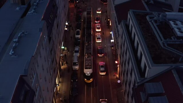 High angle view of traffic in evening city. Cars, tram and cyclist moving on illuminated street. Berlin, Germany