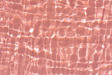 Orange water with ripples on the surface. Defocus blurred transparent pink colored clear calm water...