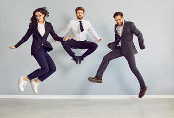 Team of crazy business people having fun in the office. Group of three happy, funny, excited, young...