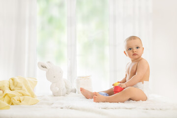 Baby in diaper playing with rubber toy