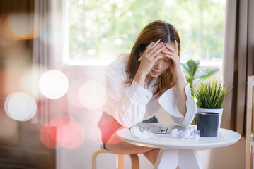 Obraz premium A young woman who is tired and overthinking from working with a tablet at home