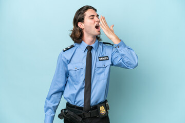 Young police caucasian man isolated on blue background yawning and covering wide open mouth with hand