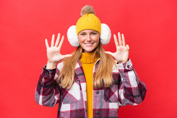 Young beautiful woman wearing winter muffs isolated on red background counting nine with fingers
