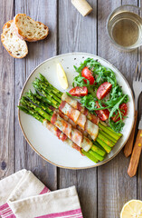 Asparagus baked with bacon and arugula and tomato salad. Healthy eating. Diet.