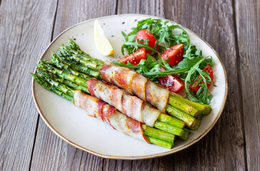 Asparagus baked with bacon and arugula and tomato salad. Healthy eating. Diet.
