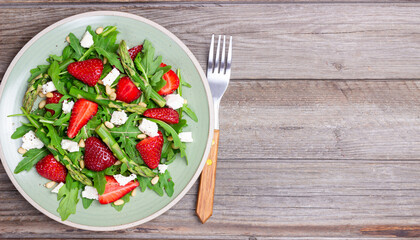 Salad with strawberries, asparagus, arugula, white cheese and nuts. Healthy eating. Vegetarian food.