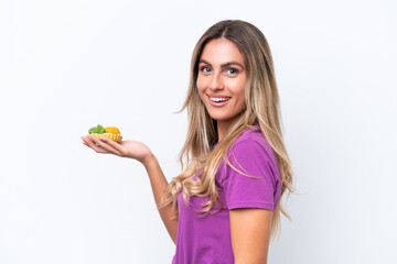 Young pretty Uruguayan woman holding a tartlet isolated on white background smiling a lot