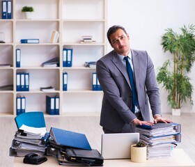 Young male employee unhappy with excessive work