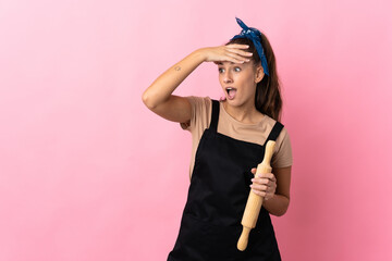 Young woman holding a rolling pin doing surprise gesture while looking to the side