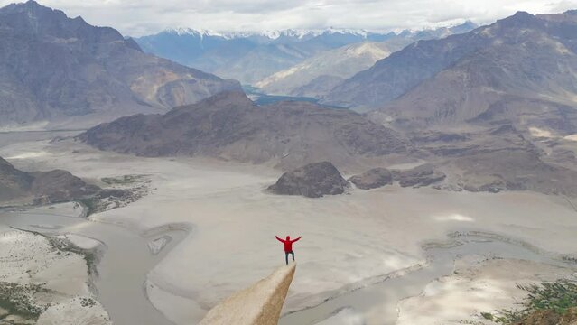 A tourist man climbing Marsur Rock cliff in Karakoram high mountain hills. Nature landscape background, Skardu-Gilgit, Pakistan. Travel on holiday vacation. People lifestyle