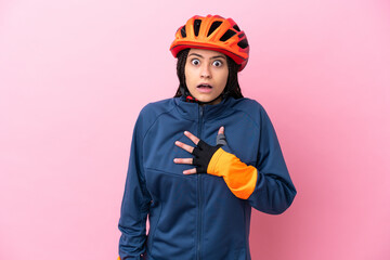 Teenager cyclist girl isolated on pink background surprised and shocked while looking right - obrazy, fototapety, plakaty