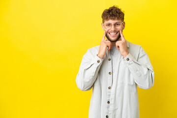 Young handsome caucasian man isolated on yellow background smiling with a happy and pleasant expression