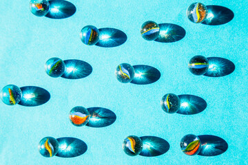 blue glass spheres with shadows on blue background, abstract pattern top view