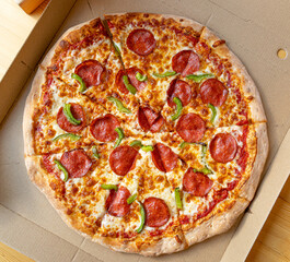 Pepperoni Pizza in Cardboard Delivery Box Closeup, Salami Pizza with Green Paprika, Chili Pepper