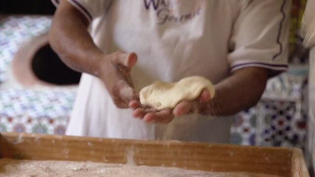 Baker Tossing Dough in Flour in Bakery and Putting Bread in Traditional Oven