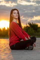 Beautiful young girl on the background of the sunset