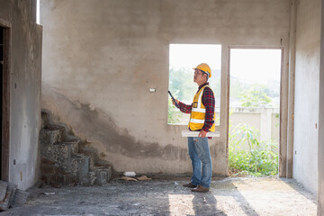 Obraz na płótnie Canvas Portrait of construction architect inspecting construction work Serious civil engineer with documents on construction site professional foreman in the workplace