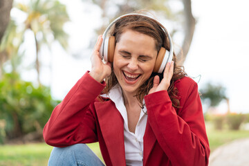 Young caucasian woman at outdoors listening music