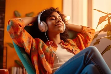 Poster Young woman in headphones listening to music at home. Girl sitting on  sofa © ttonaorh