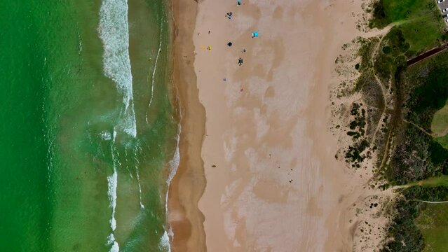 South Africa JBAY Jeffreys Bay aerial drone town homesmost stunning white sand beach epic surf wave saturated aqua blue rugged reef coastline daytime people on beach with umbrellas summer looking down