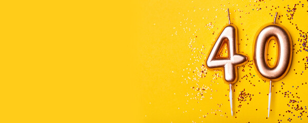 40 years celebration. Greeting banner. Gold candles in the form of number forty on yellow...