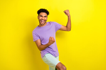 Fototapeta na wymiar Photo of pretty lucky guy dressed purple t-shirt screaming rising fists isolated yellow color background