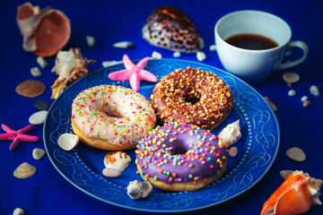Assorted donuts in a plate on a blue background.