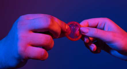 Closeup of couple giving condom. Condom in male hand and female hand, give condom safe sex concept....
