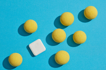 Flat lay creative background for advertising with healthcare and medicine concept. On the blue background, some yellow pills decorated white mint lozenges