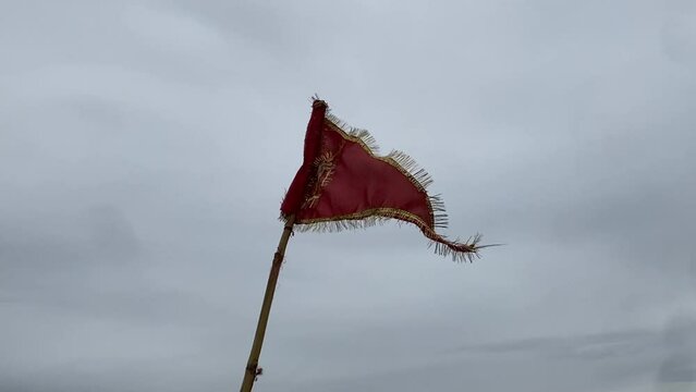 A Hindu Bajrang bali Flag is fluttering in a cloudy sky.