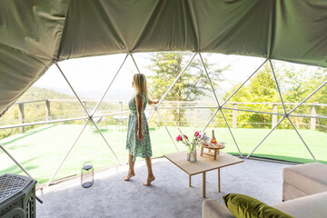 Transparent bubble tent at glamping, Lush forest around and interior. woman resting in glamping