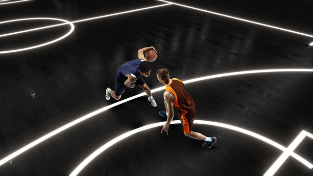 Aerial view of professional two basketball players in action with basketball ball at 3d model sports arena. - Powered by Adobe